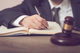 Richter sitzt an Schreibtisch und macht Notizen